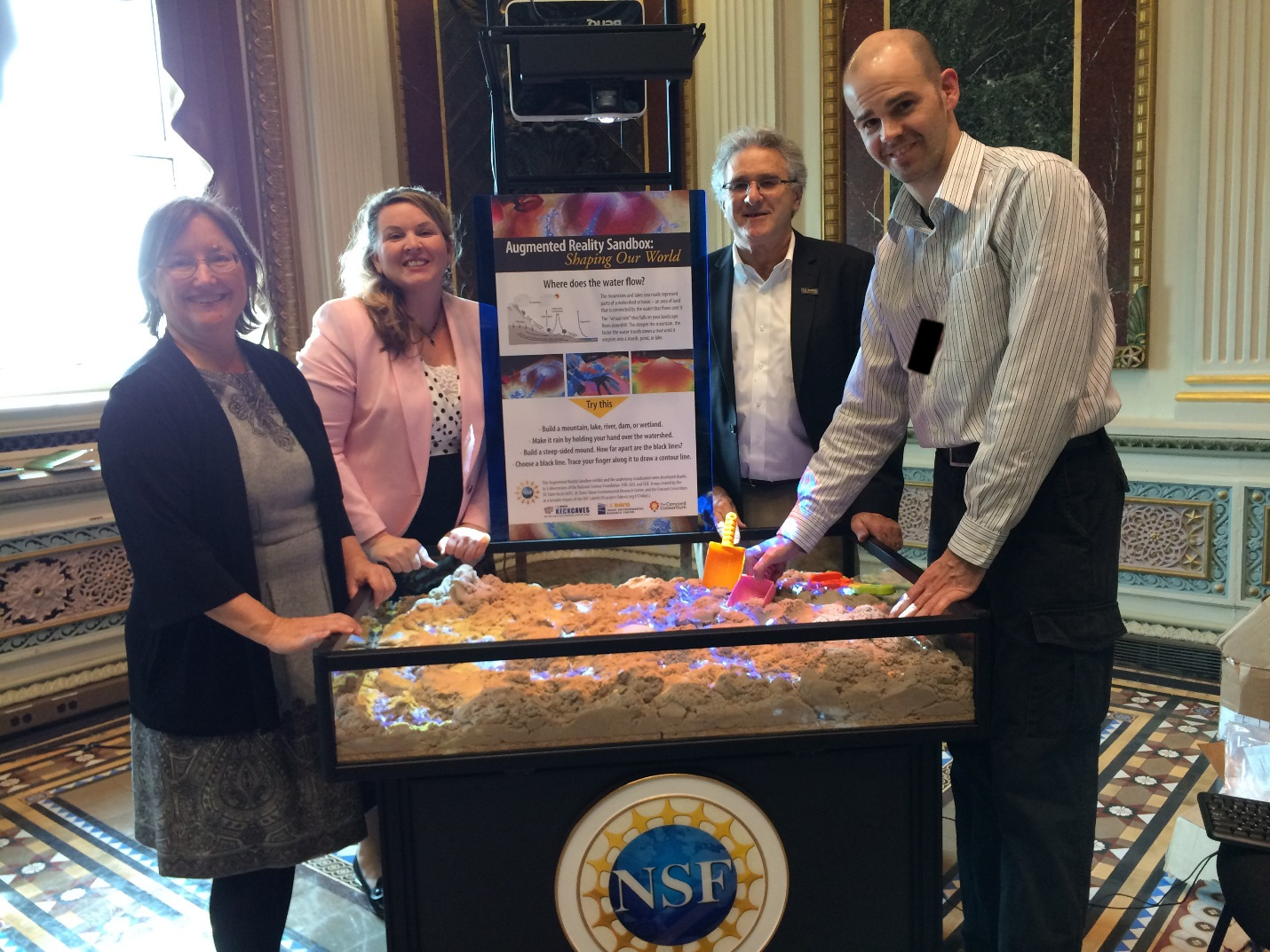 New commercial-grade AR Sandbox model at the White House Water Summit, 03/22/2016. Left to right: Dr. Louise H. Kellogg, Neysa Call (Legislative Aide and Grants Director for Senate Democratic leader Harry Reid), Dr. S. Geoffrey Schladow, Dr. Oliver Kreylos. Photo credit: Terry Davies, National Science Foundation.